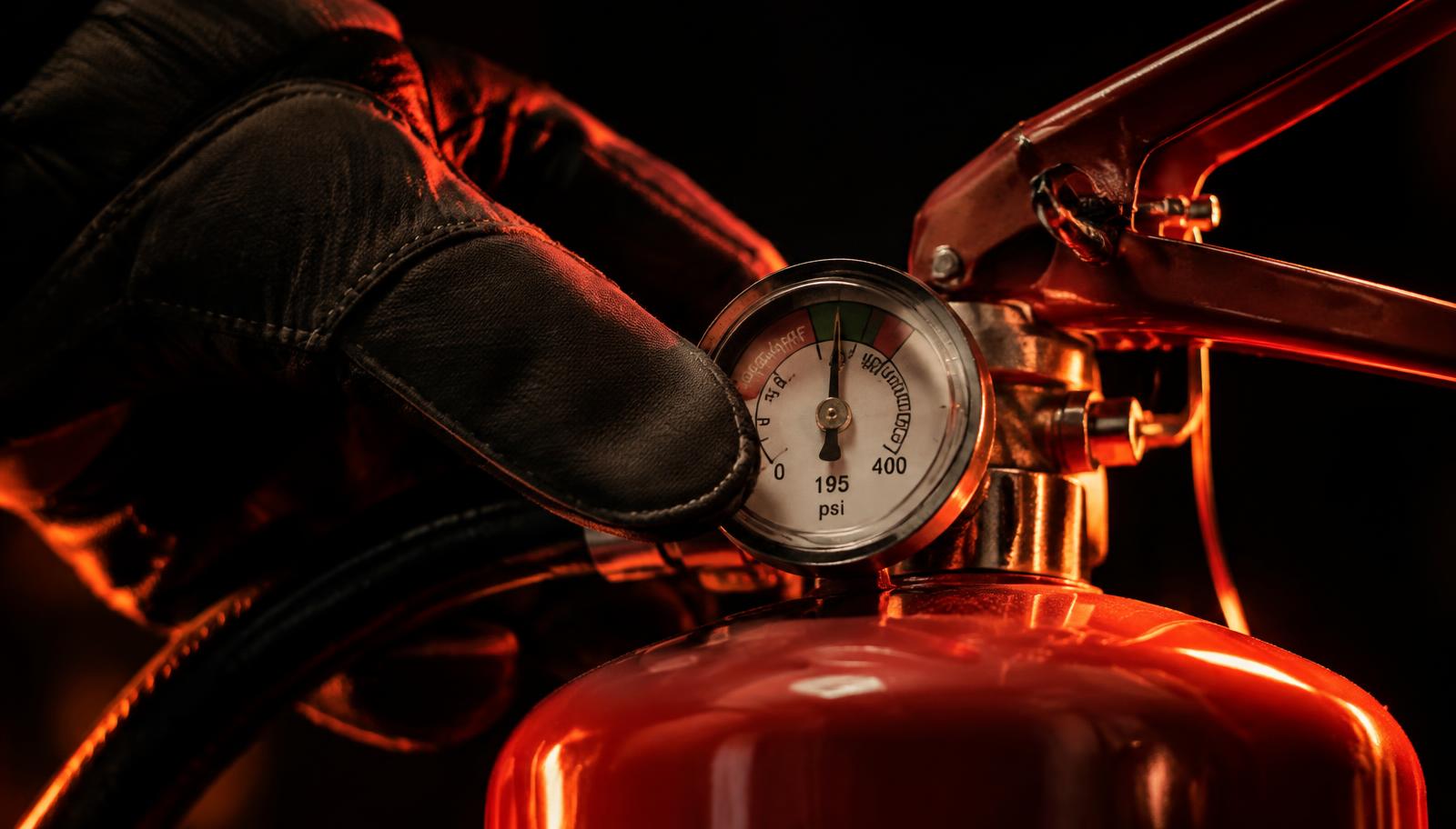 Technician checking a fire extinguisher pressure gauge